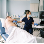 Ultrasound probe on the side of a man's chest during an echocardiogram