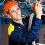 Construction repairman with a combination pliers on a stepladder