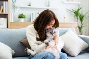 young Domestic Violence young woman cuddling cat on couch